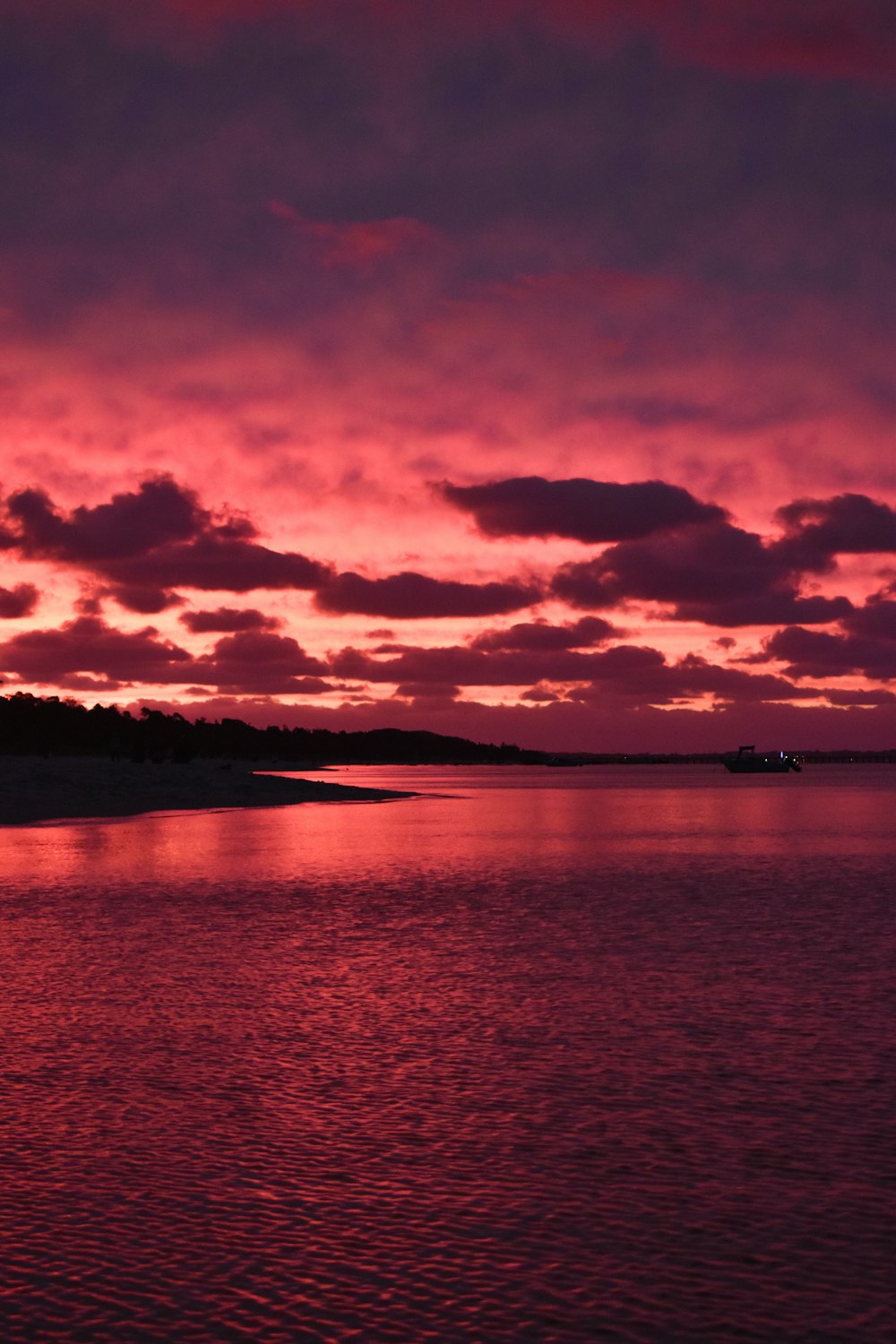 body of water under cloudy sky during sunset