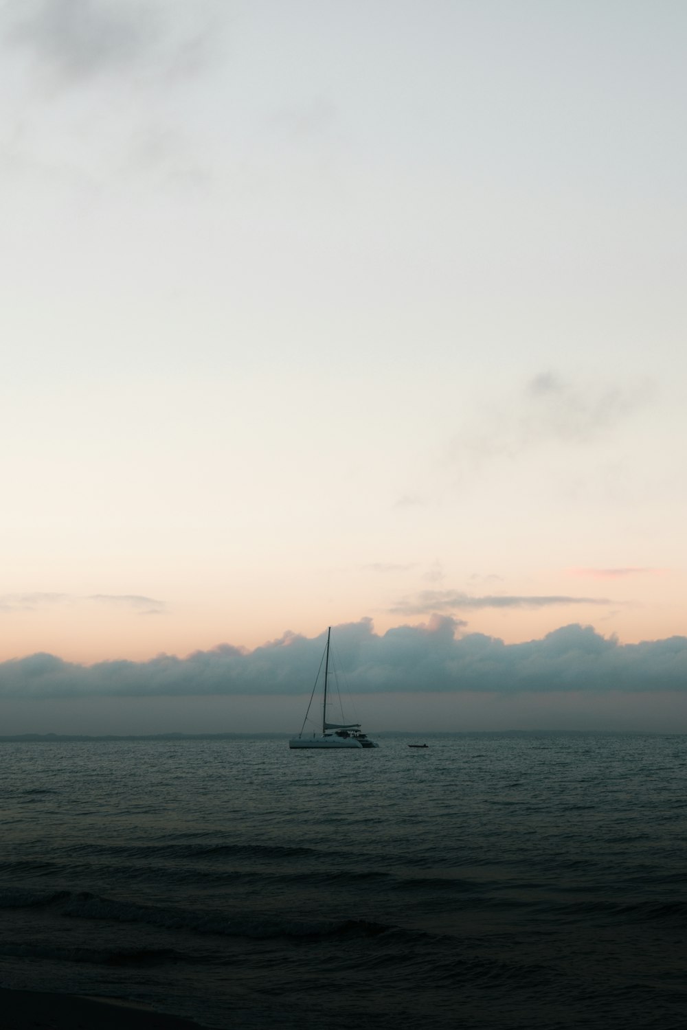 sailboat on sea under white sky during daytime