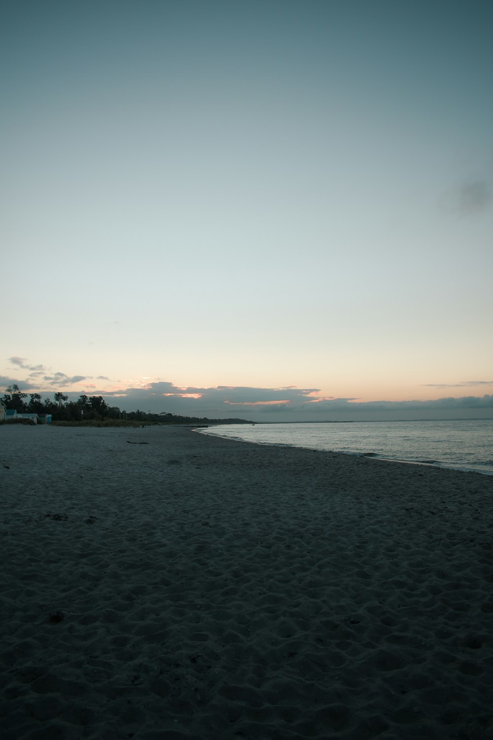 Gente en la playa durante la puesta de sol