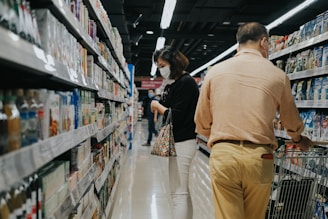 man in brown long sleeve shirt and brown pants standing beside woman in black and white