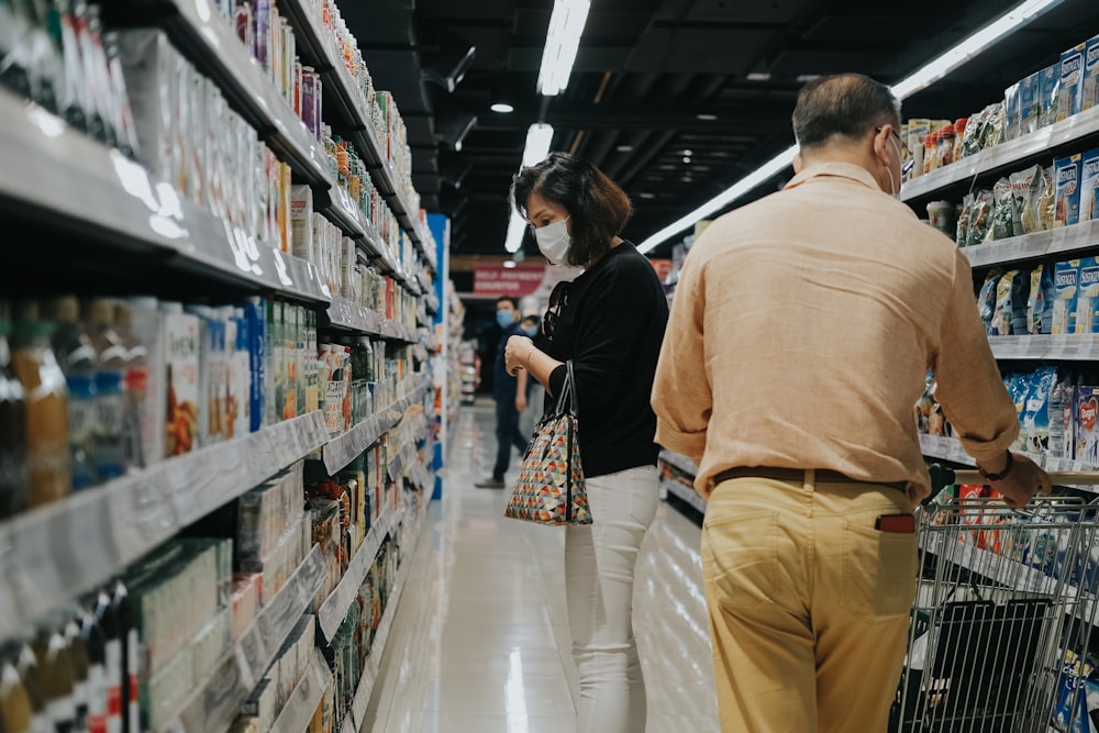 man in brown long sleeve shirt and brown pants standing beside woman in black and white