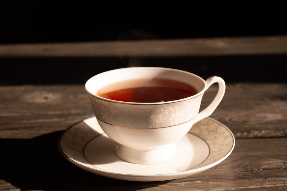 tasse à thé en céramique blanche sur soucoupe en céramique blanche