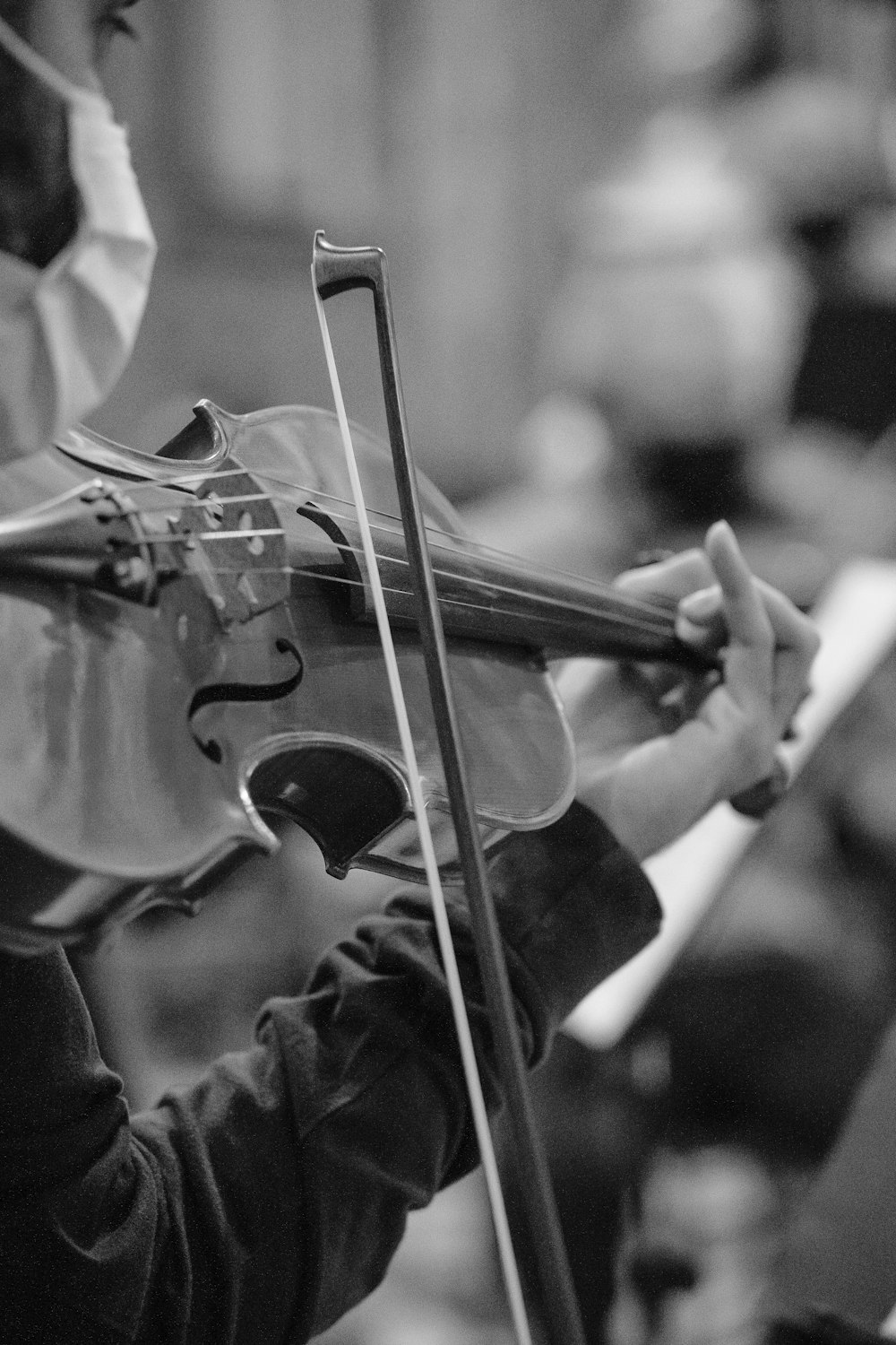 person playing violin in grayscale photography