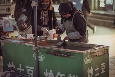 Friendly women team members preparing samosas in a spotless kitchen.