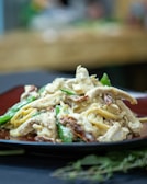 A close-up of a creamy pasta dish garnished with herbs.