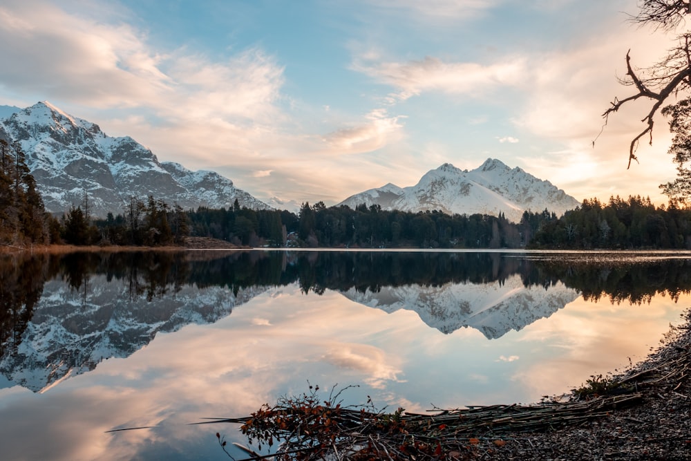 Lago cerca de la montaña bajo nubes blancas durante el día