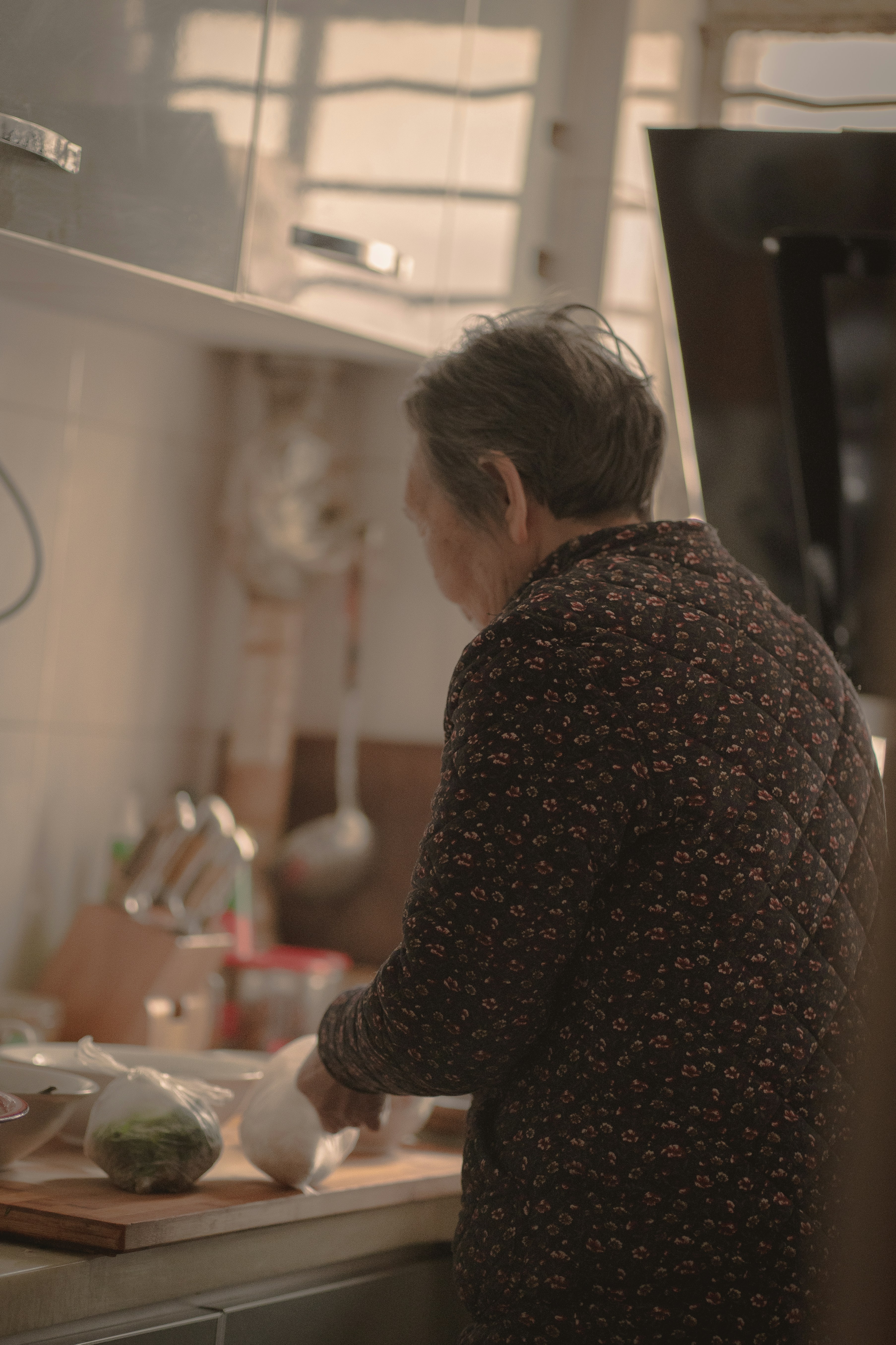 woman in brown and white long sleeve shirt standing in front of table