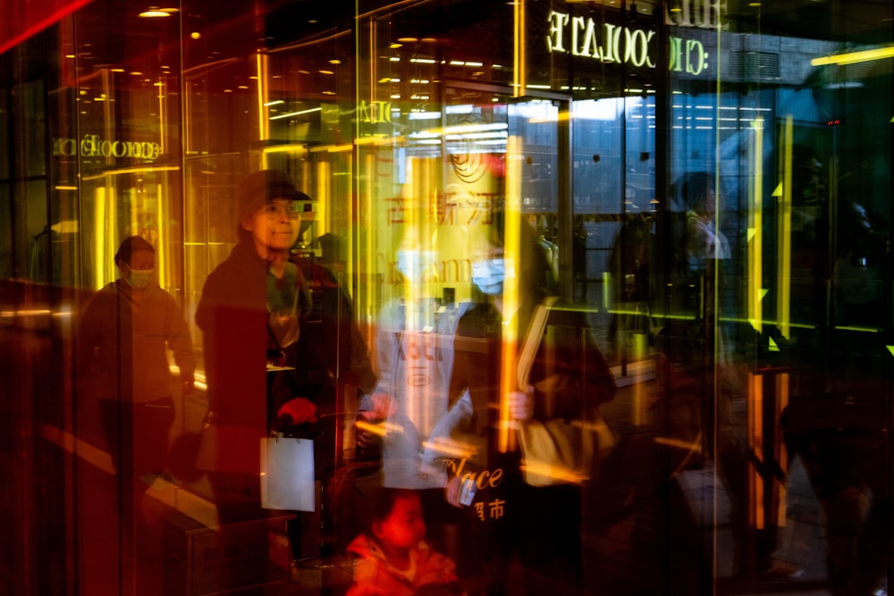 man in black blazer standing near glass window