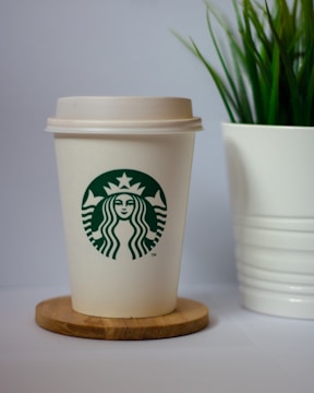 Eco-friendly coffee setup with a reusable cup and a small plant nearby.