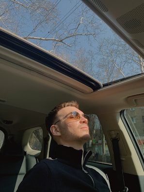 A person enjoying music while driving on a sunny day.