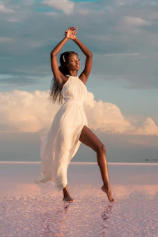 woman in white dress standing on beach during daytime