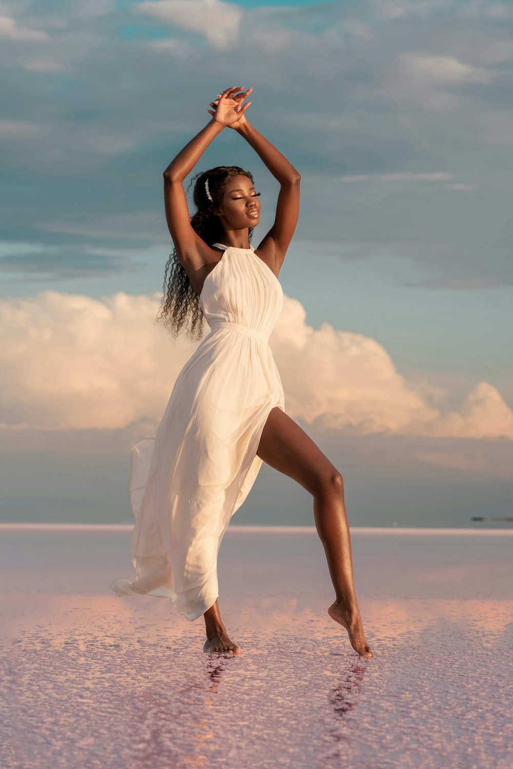 woman in white dress standing on beach during daytime