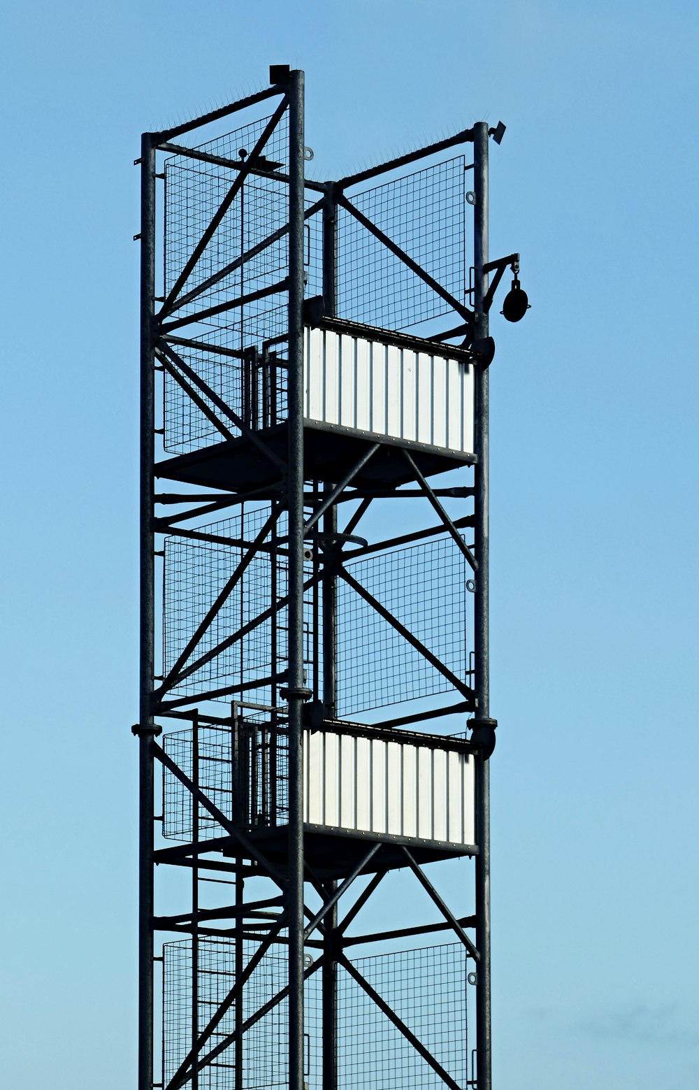 black metal spiral stairs under blue sky during daytime