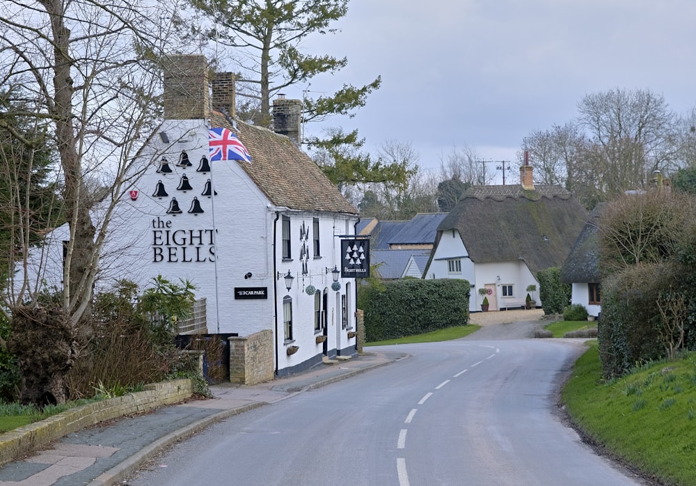 white and black wooden house beside gray asphalt road during daytime