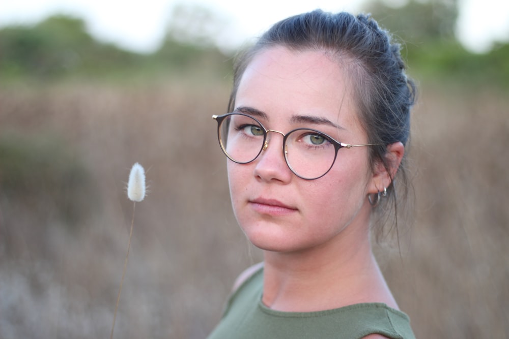 Mujer con camisa verde de cuello redondo con gafas de montura negra