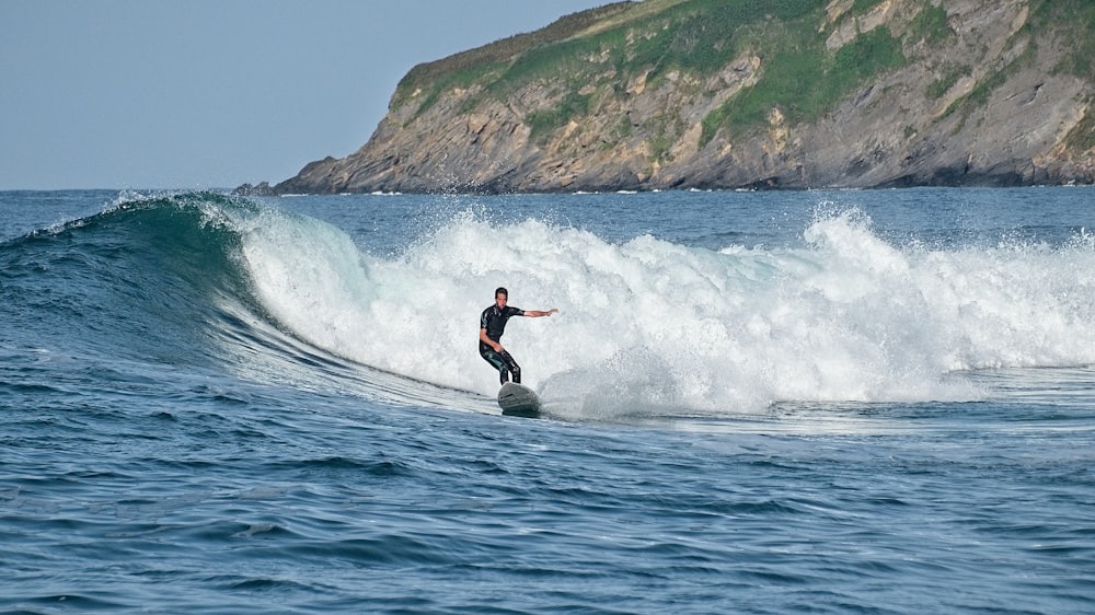 man surfing on sea waves during daytime