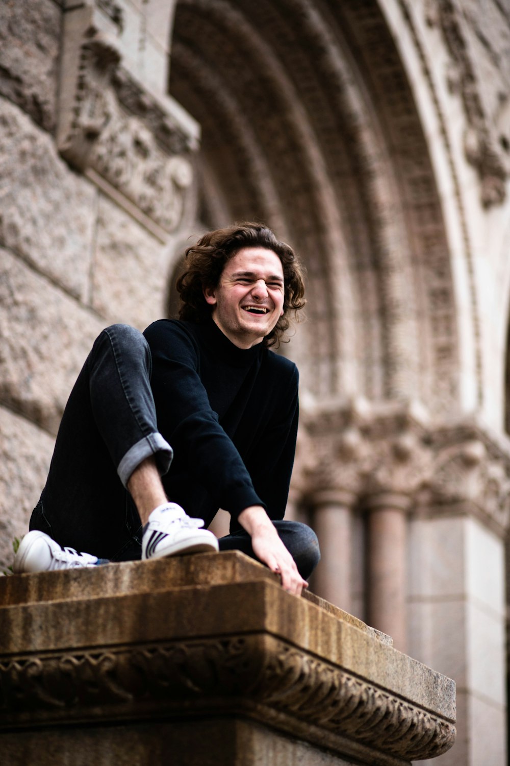 woman in black long sleeve shirt and black pants sitting on brown wooden bench