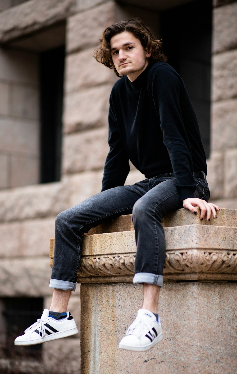 Foto hombre con chaqueta negra con cremallera y jeans azules sentado en un  banco de concreto marrón durante – Imagen Illinois gratis en Unsplash