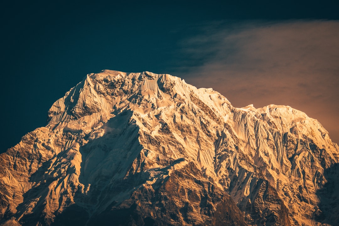 brown and white mountain under gray sky