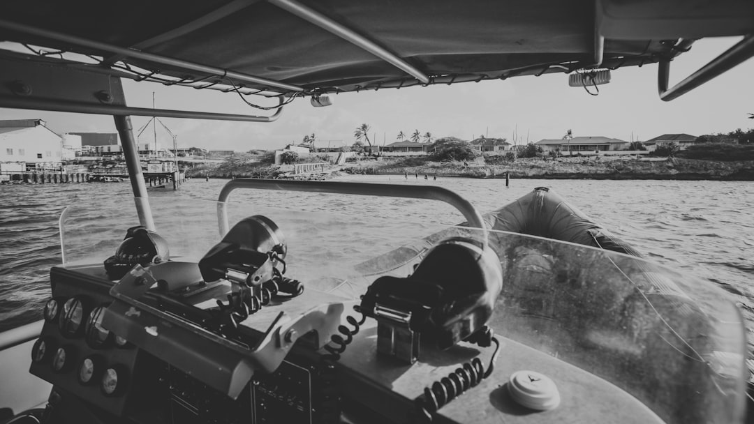 grayscale photo of 2 men riding on boat