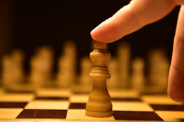 Close-up of hands moving chess pieces, representing strategic decision-making.