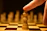 A focused young student thoughtfully planning a chess move under soft, warm lighting.