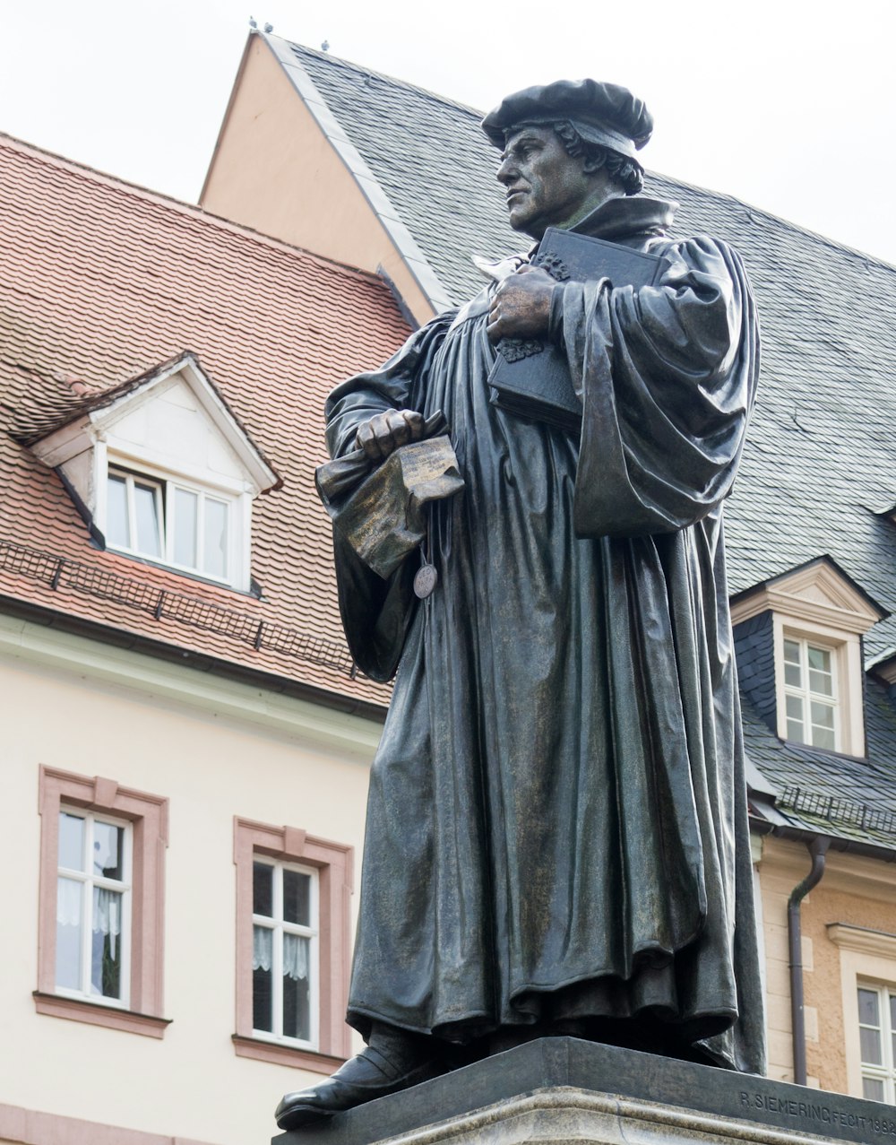 Hombre en la estatua del abrigo negro