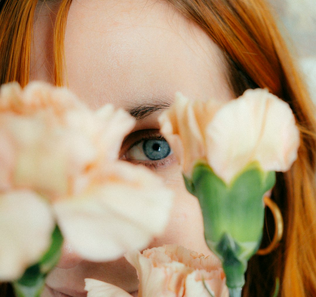 womans face with white flower on her ear