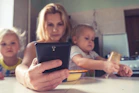 woman in white shirt holding black ipad
