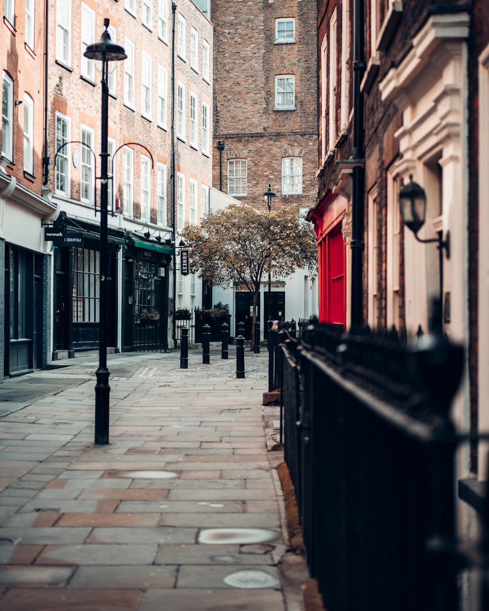 brown brick pathway between brown concrete buildings during daytime