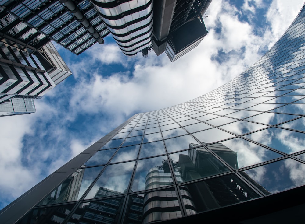 worms eye view of glass building under blue and white sunny cloudy sky during daytime