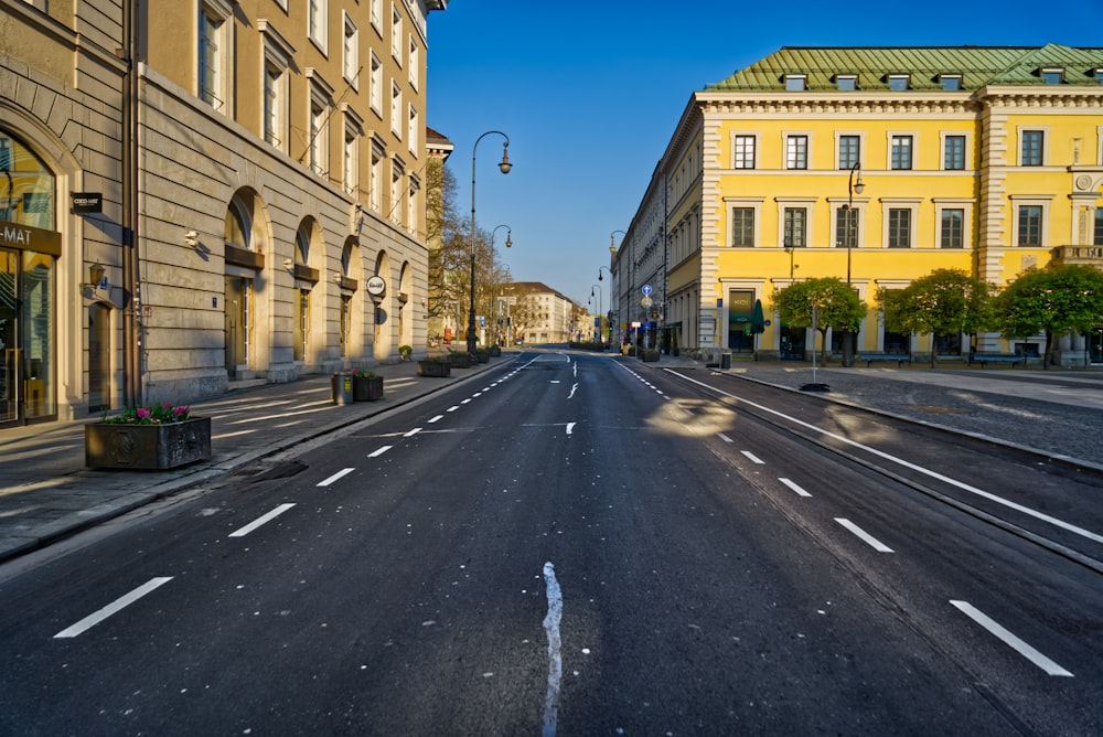 empty road between beige concrete building during daytime