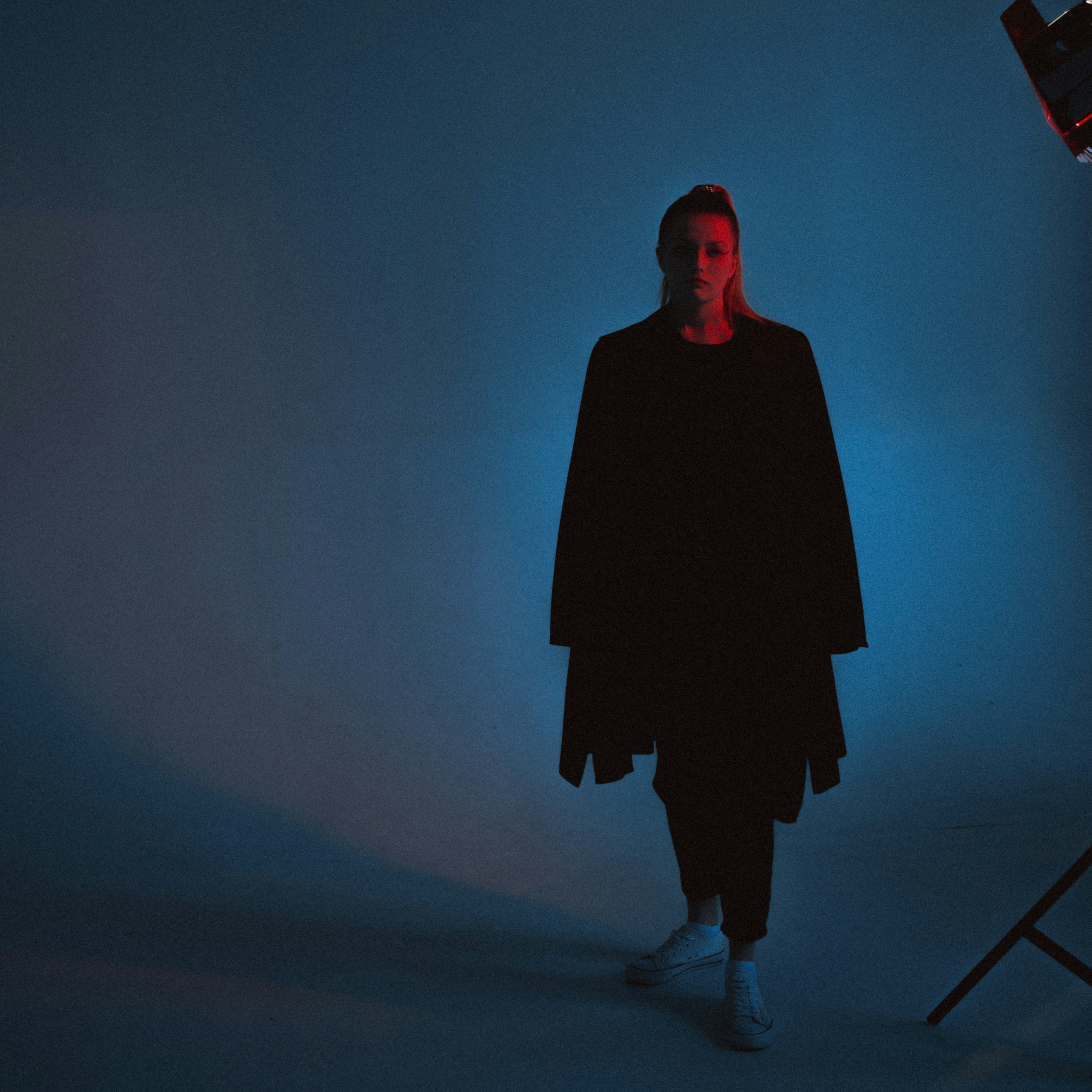 femme en manteau noir debout sur la scène