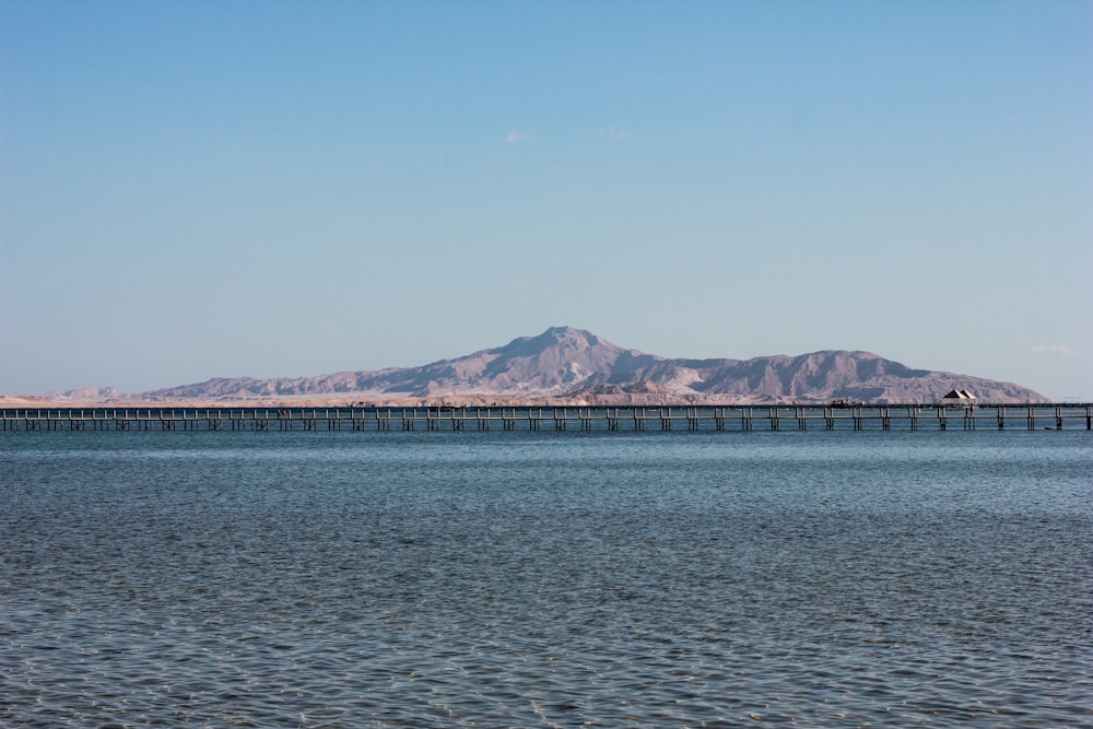 blue sea near mountain under blue sky during daytime