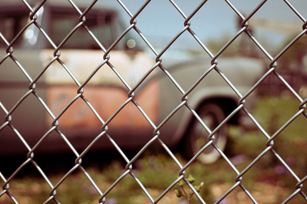 silver car parked beside gray metal fence