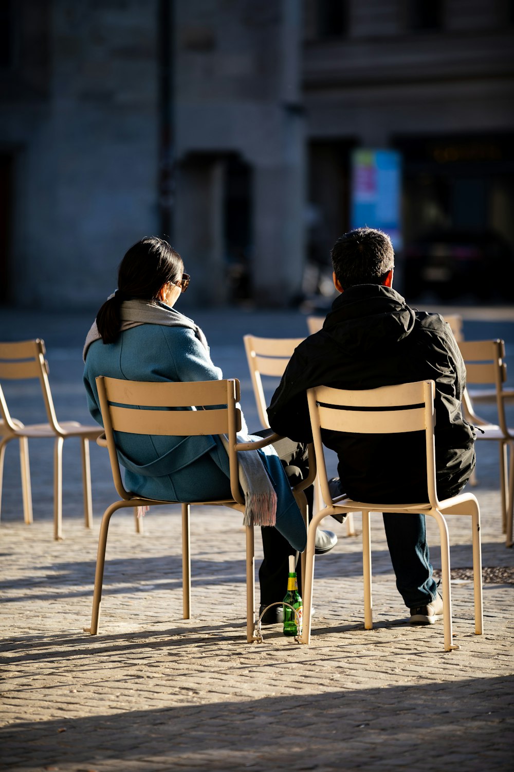 man and woman sitting on white wooden chair during daytime