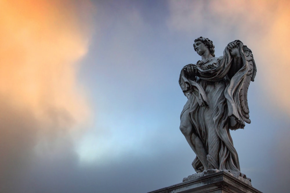 statue of man holding book