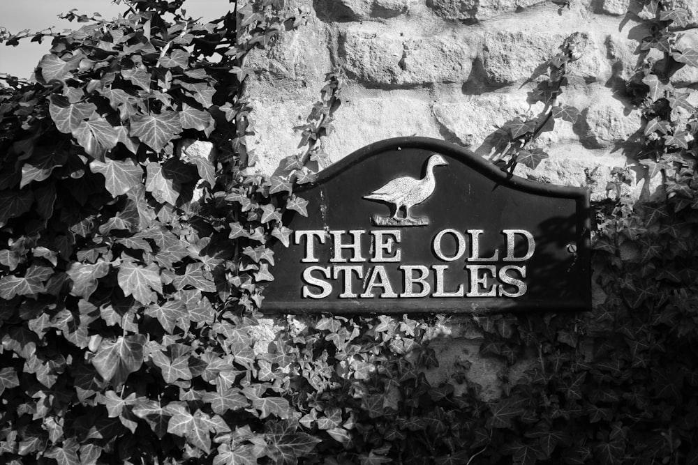 a black and white photo of a sign for the old stables