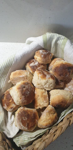 Close-up of a rustic basket filled with colorful muffins and scones from local bakers.
