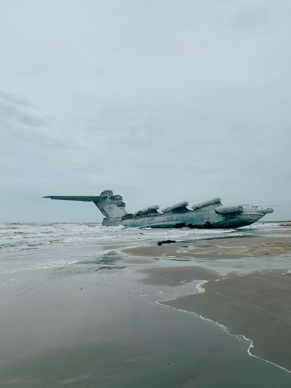 aereo da combattimento grigio sulla sabbia grigia durante il giorno
