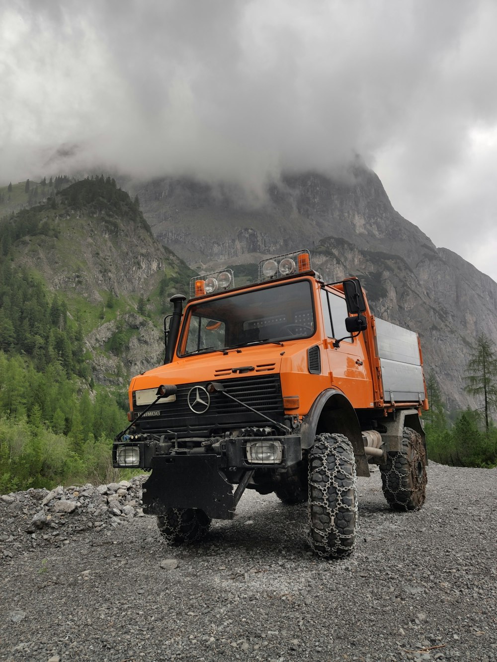 orange and white jeep wrangler on rocky ground