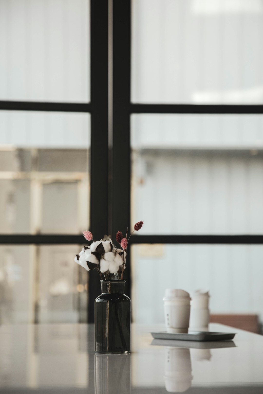 white and red flowers in black glass vase