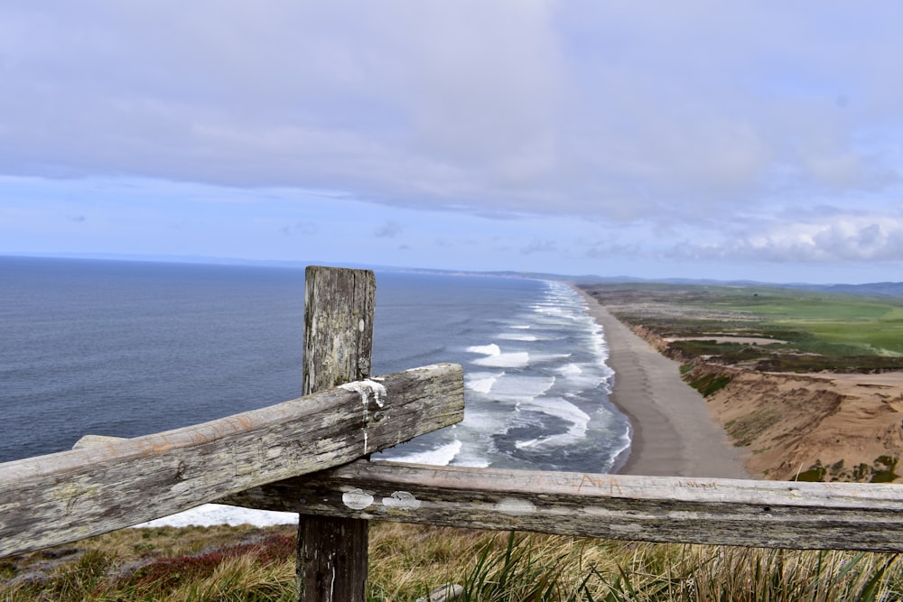 brown wooden fence on seashore during daytime