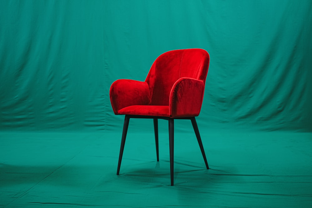 red and black chair beside green wall