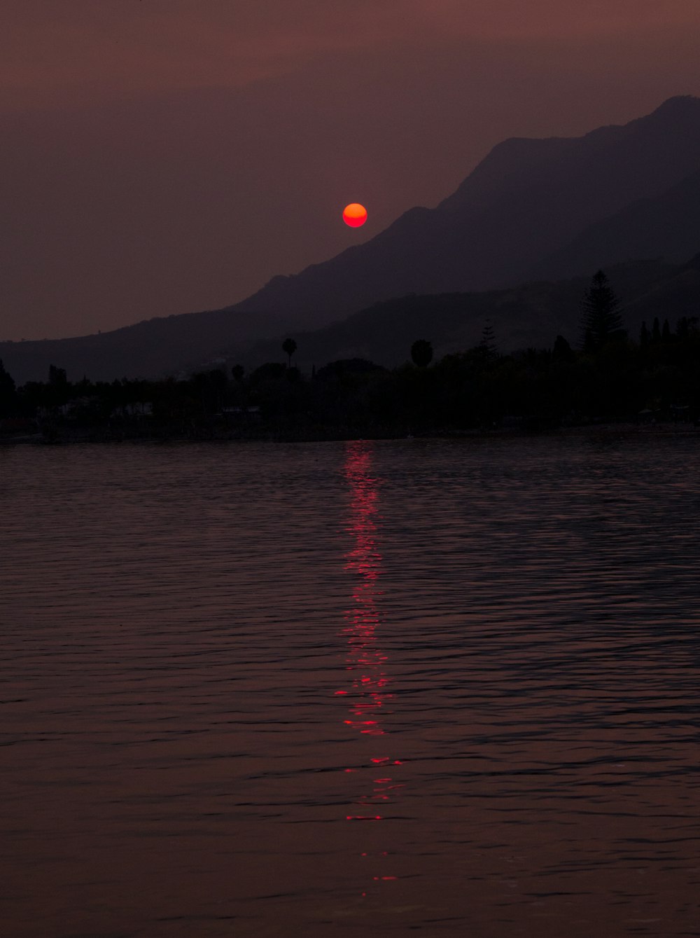 Cuerpo de agua cerca de la montaña durante la puesta de sol