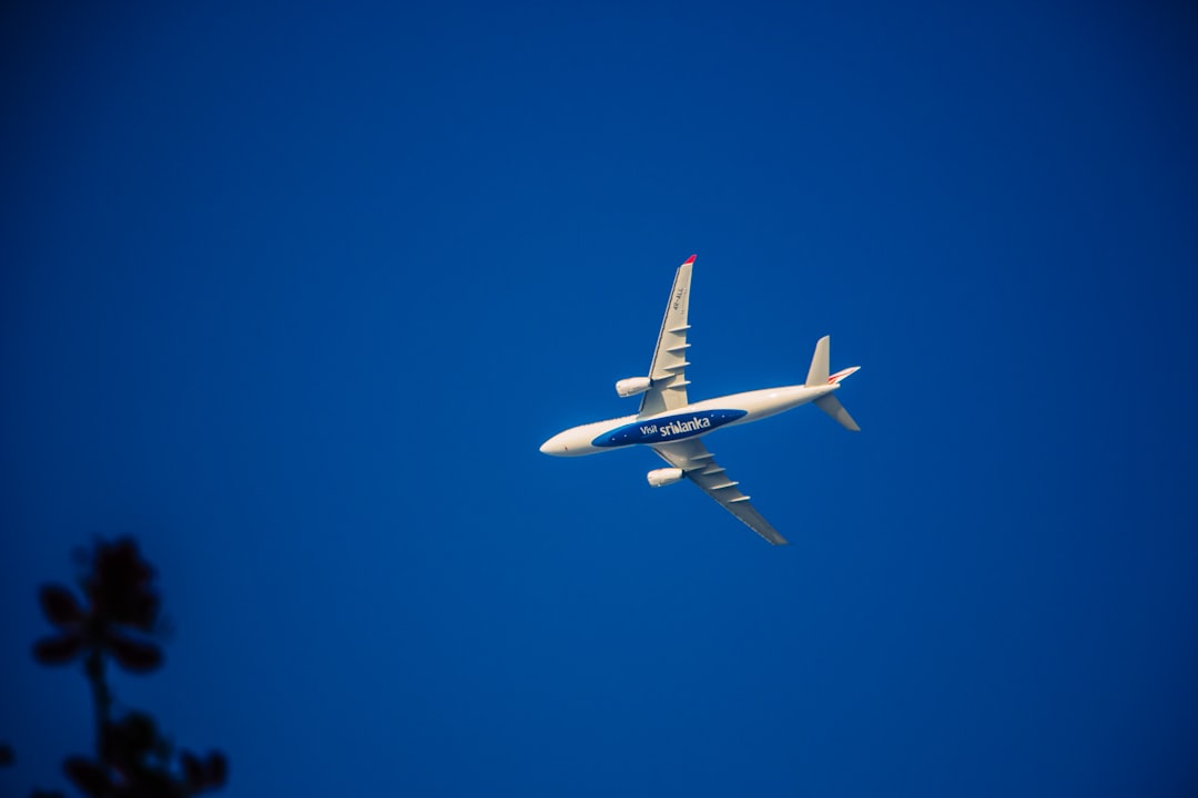 white and blue airplane in mid air