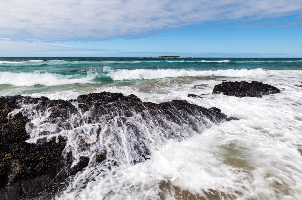 ocean waves crashing on shore during daytime