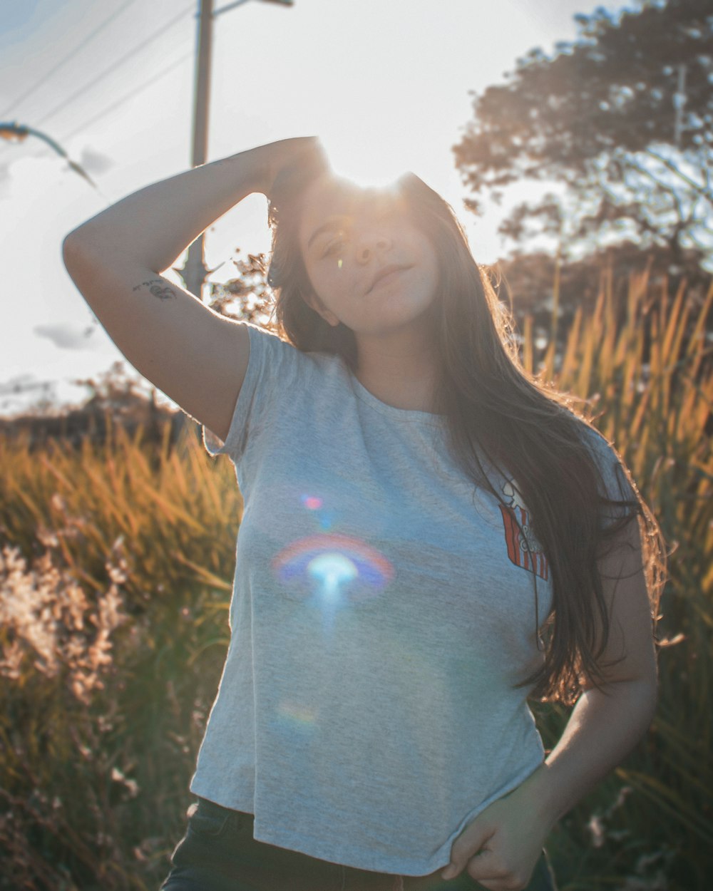girl in blue crew neck t-shirt standing on brown grass field during daytime