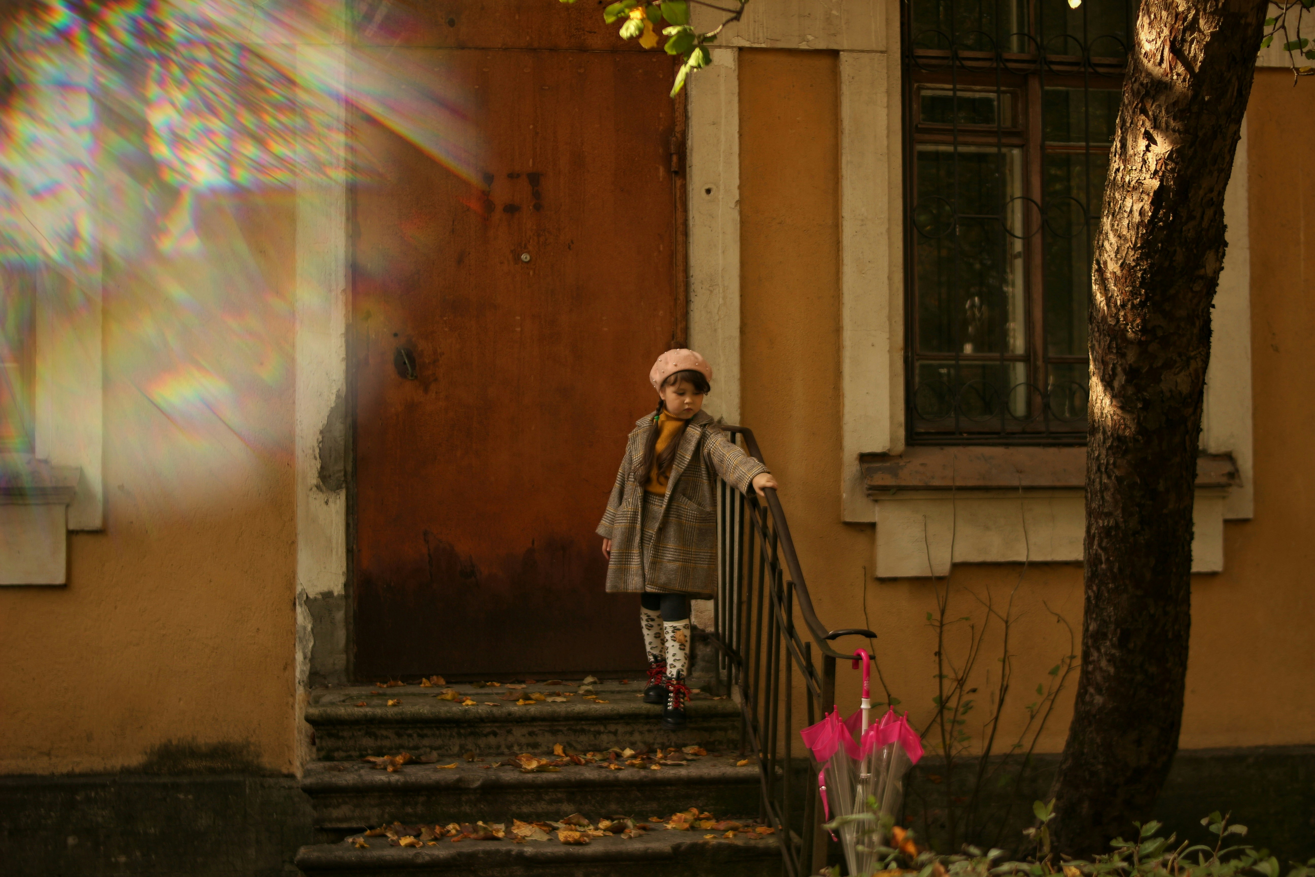 woman in brown coat standing on the sidewalk with bubbles