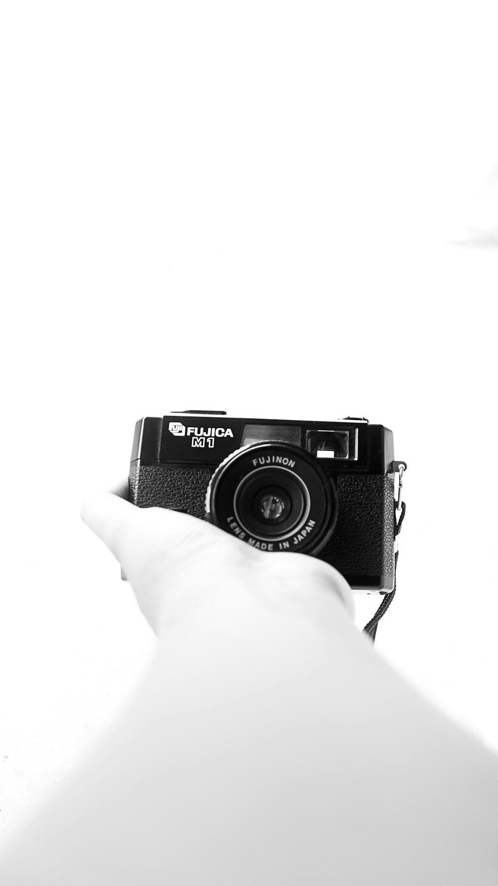 a black and white photo of a person holding a camera